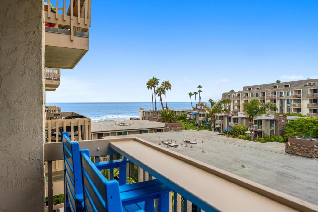 a balcony with blue chairs and the ocean in the background at A217 - Blue Water Escape in Oceanside