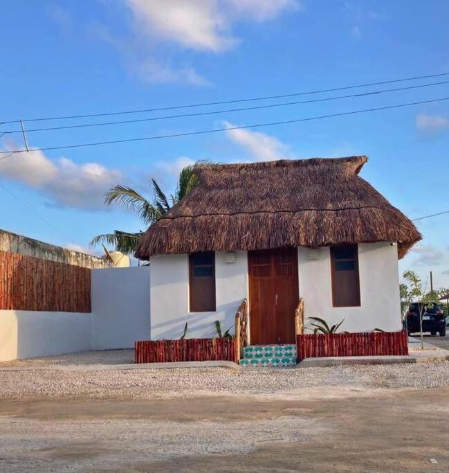 a small white house with a thatch roof at La conchita de sisal 3 in Sisal