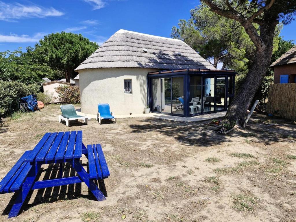 une table de pique-nique bleue et des chaises devant une maison dans l'établissement Résidence Ile Des Pecheurs - VILLA 3 PIECES 6 couchages LE BARCARES MAE-7034, à Port-Leucate