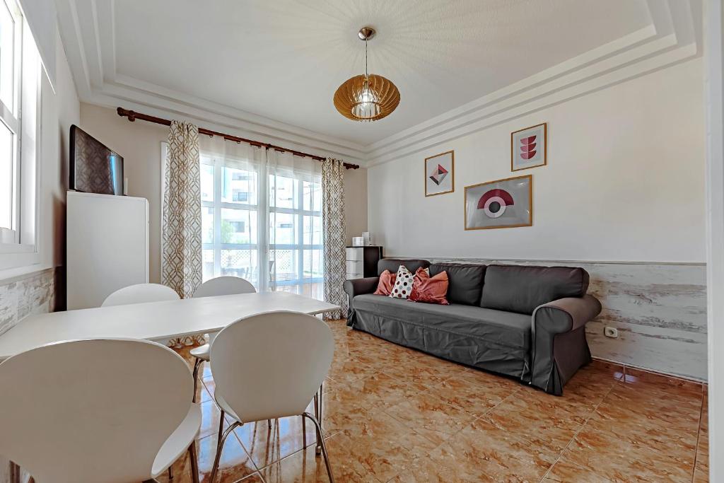 a living room with a couch and a table and chairs at Tenerifeopenhome Costa Adeje comfort apartment 3 pools in Adeje