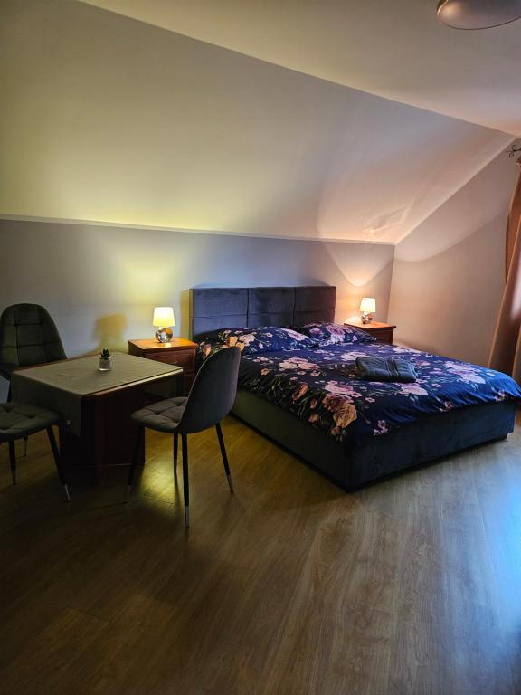 a bedroom with a bed and a table and chairs at DOMKI w Zaciszu in Ruś