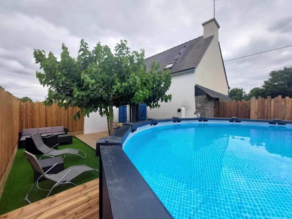 a swimming pool in the backyard of a house at Maison Bretonne avec piscine in Marzan