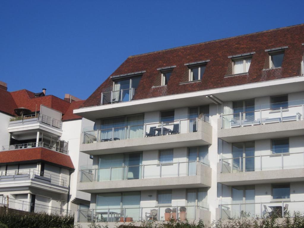 an apartment building with balconies and a red roof at Zoutezoute in Knokke-Heist