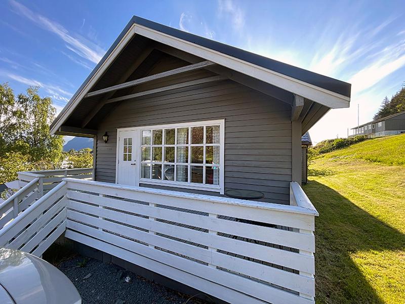 a small house with a porch and a window at Selje Camping - Hytte Nr 4 in Selje