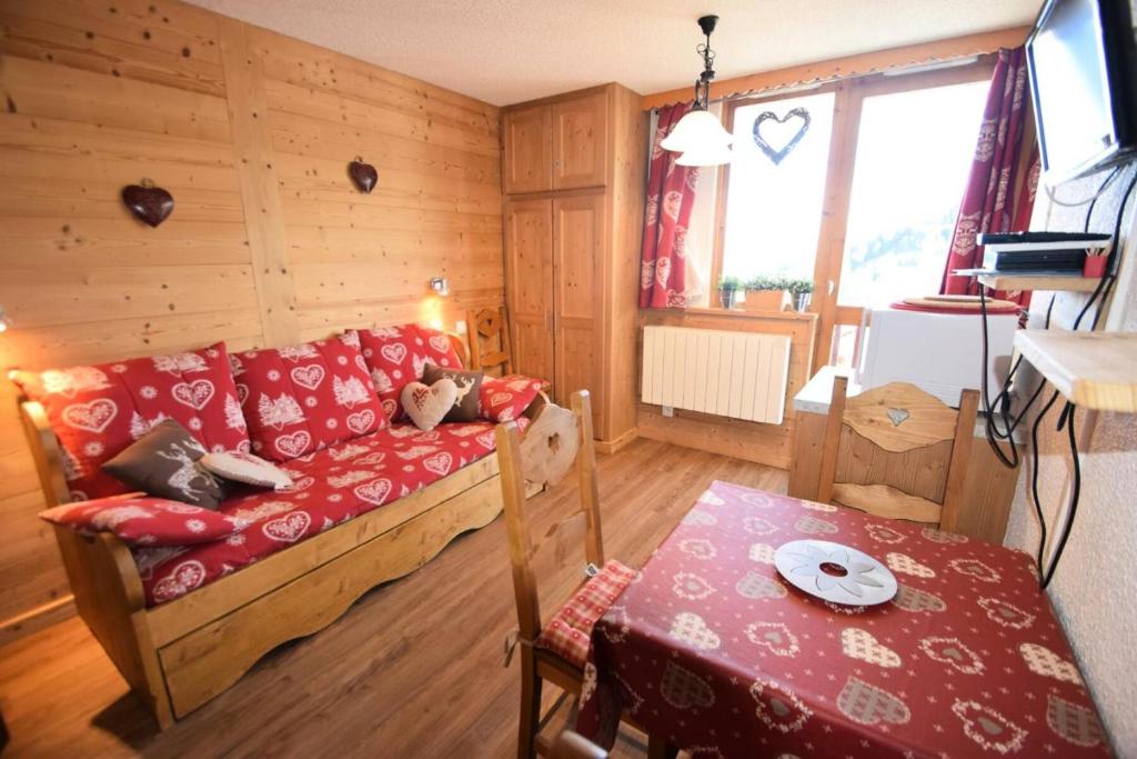 Cette petite chambre comprend un canapé et une table. dans l'établissement Résidence Les Hameaux I - Studio 3/4 pers - LES HAMEAUX I PLAGNE VILLAGES MAE-9094, à Aime La Plagne