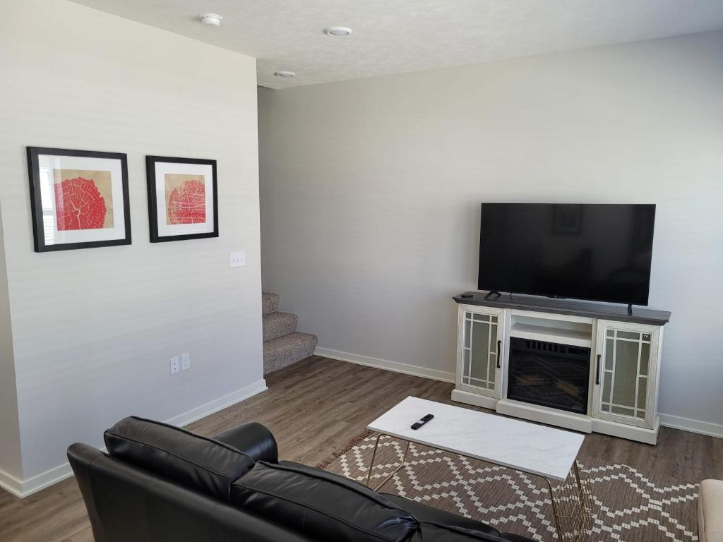 a living room with a couch and a flat screen tv at The Cottonwood at Coventry Rows in Omaha