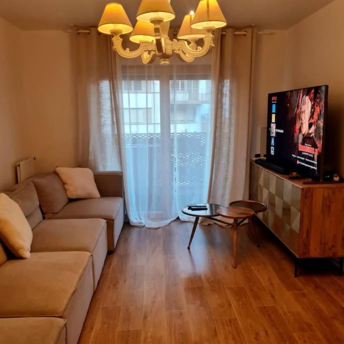 un salon avec un canapé et une télévision dans l'établissement Appart Cosy Family near JO2024, à Saint-Denis