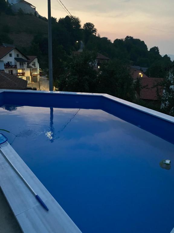 a blue swimming pool with a view of a house at Villa Sun Visoko in Visoko