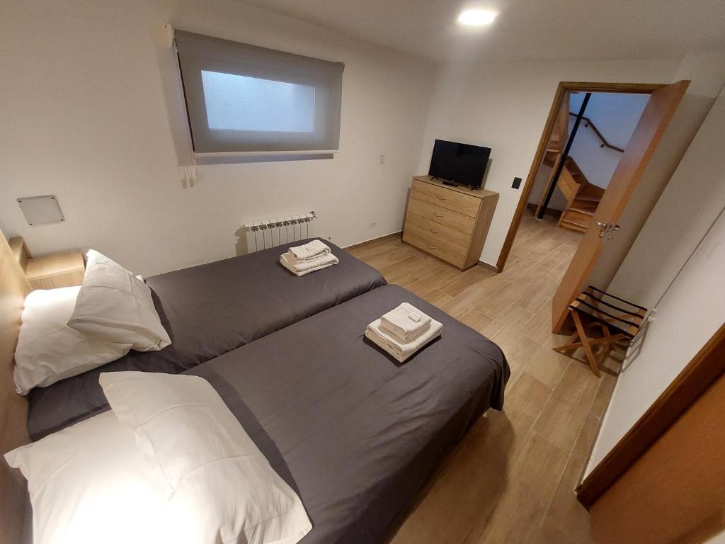 een slaapkamer met een groot bed en een televisie bij Casa Laura Bariloche in Bariloche