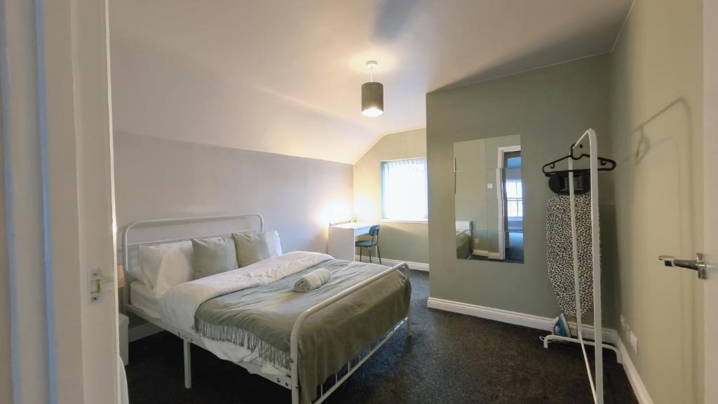 a small bedroom with a bed and a mirror at Birmingham City Stay Apartments in Birmingham