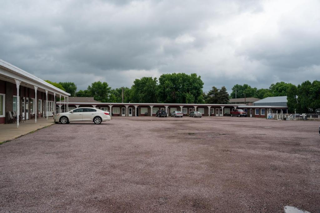 a white car parked in front of a building at Siesta Motel in Mitchell