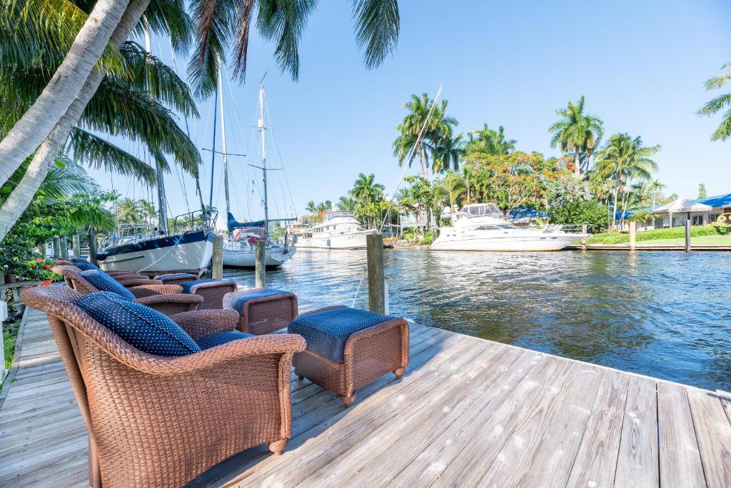 a group of chairs sitting on a dock next to the water at The Riverside Retreat 2 in Fort Lauderdale