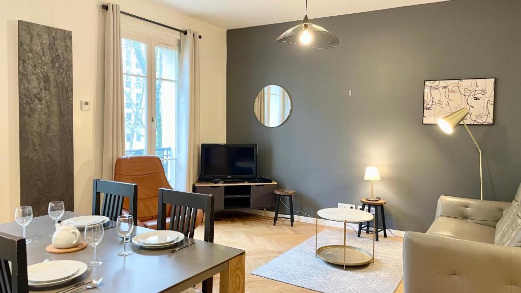 - un salon avec une table, un canapé et une télévision dans l'établissement 107 - Tour Eiffel Appartement luxe 15ème, à Paris