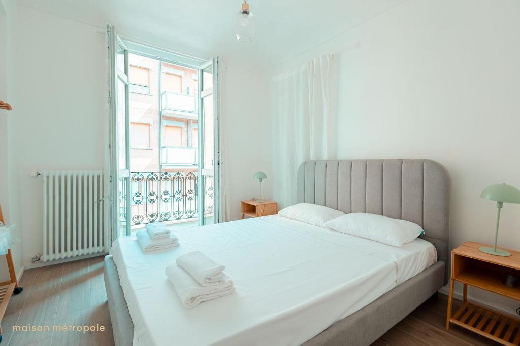 a bedroom with a white bed with towels on it at Odissea House in Turin