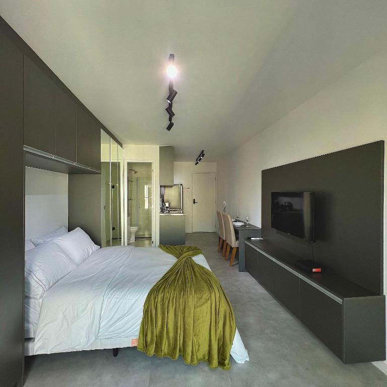 a bedroom with a bed and a flat screen tv at Studio Prime 1510 - Higienópolis in Sao Paulo