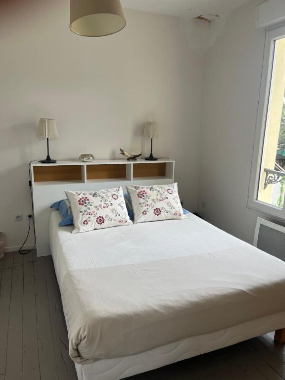 une chambre avec un lit avec deux oreillers dessus dans l'établissement Maison Colombes, à Colombes