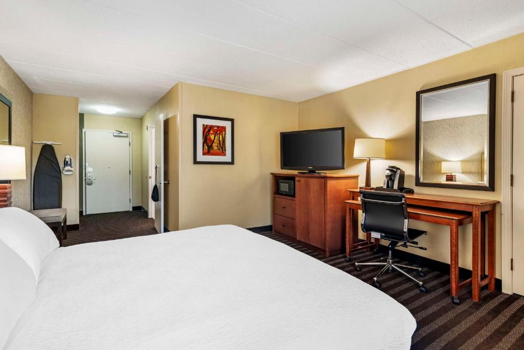 a hotel room with a bed and a desk and a television at Best Western Springfield Hotel in Springfield