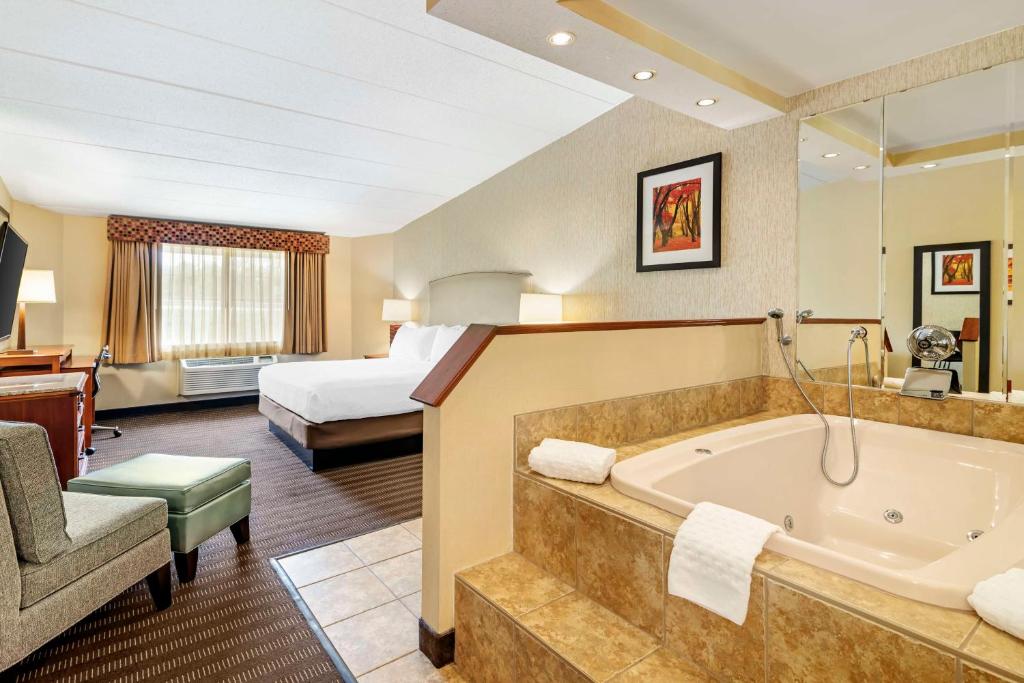a hotel room with a tub and a bed at Best Western Springfield Hotel in Springfield