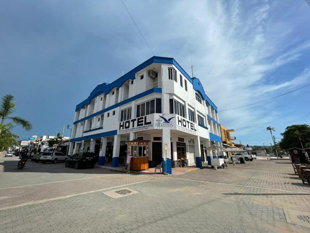 a large white and blue building on a street at Hotel Albatros in Pe&ntilde;ita de Jaltemba