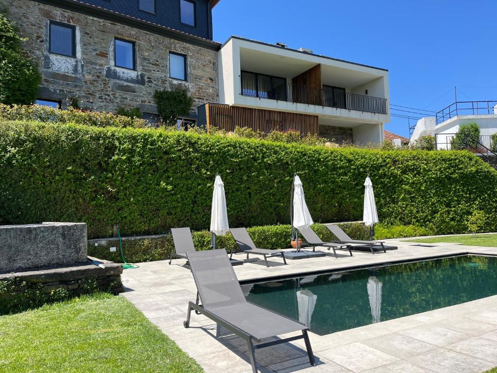 a group of chairs and umbrellas next to a pool at FLH Douro Casa do Mártir in Vila Marim