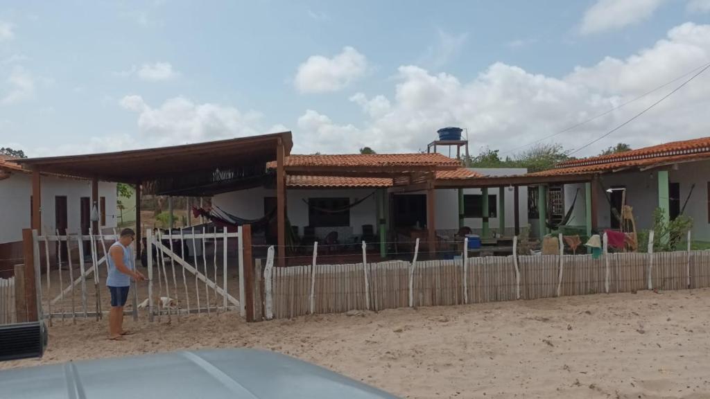 Ein Mann steht vor einem Haus in der Unterkunft Casa Gael (Gisele & Lucimar) in Atins