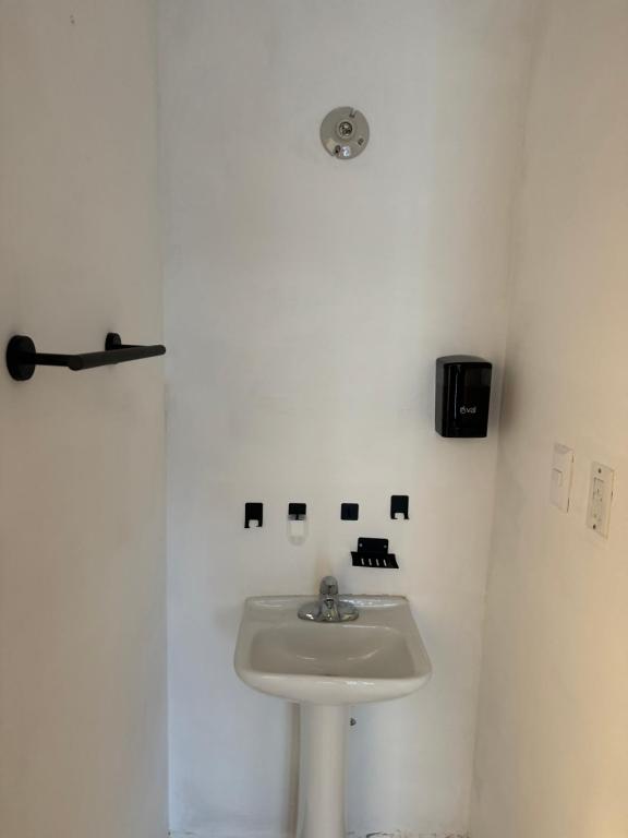 een badkamer met een wastafel en een witte muur bij Bienvenidos a tu segundo hogar! in Altamira