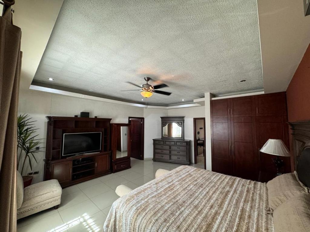 デュランゴにあるCasa en venta DURANGOのベッドと天井扇風機のある寝室
