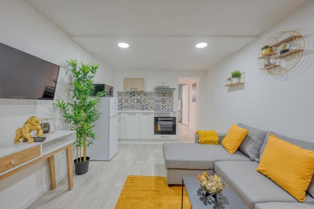 un salon avec un canapé et une cuisine dans l'établissement Lux Suite Lorenzo, à Livry-Gargan