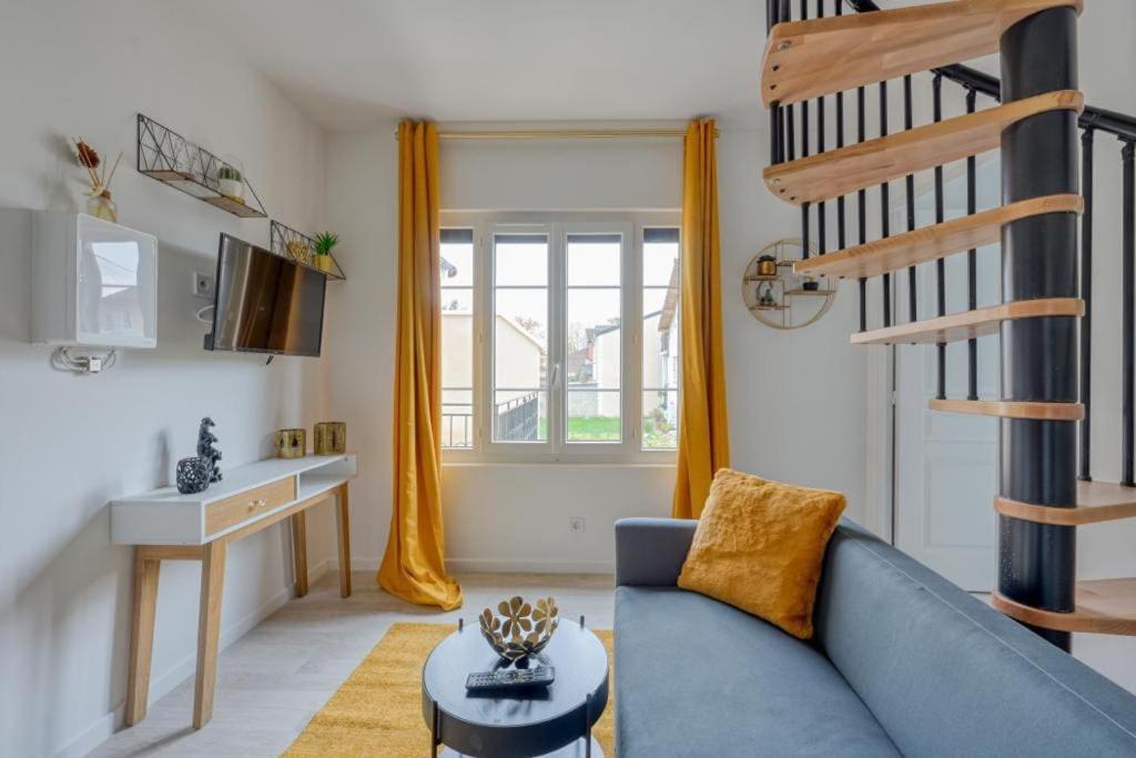 - un salon avec un canapé bleu et un escalier dans l'établissement Lux Suite Eliana, à Livry-Gargan