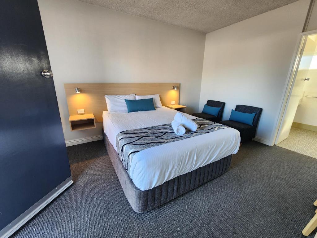 una camera d'albergo con un letto con un animale di peluche di Country Gardens Motel a Coonabarabran
