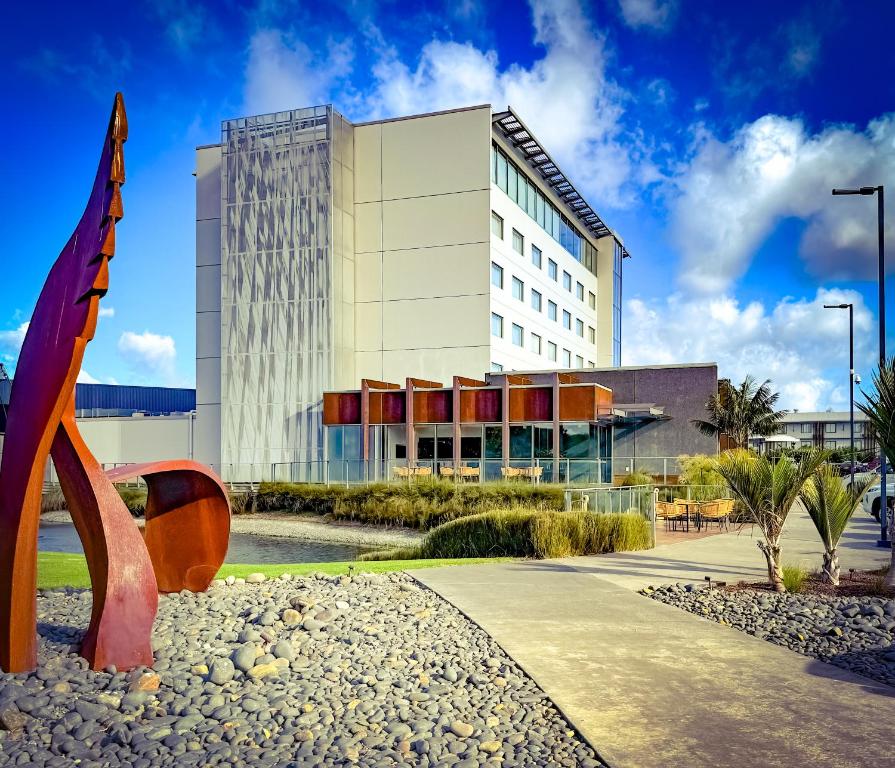 a building with a sculpture in front of it at JetPark Auckland Airport Hotel in Auckland