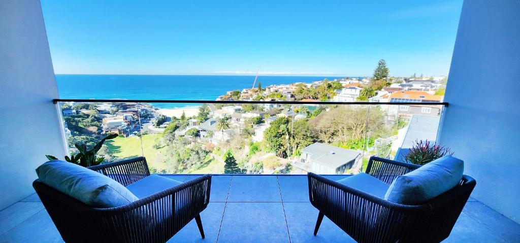 a balcony with two chairs and a view of the ocean at Coastal Luxury overlooking Tamarama Beach in Sydney