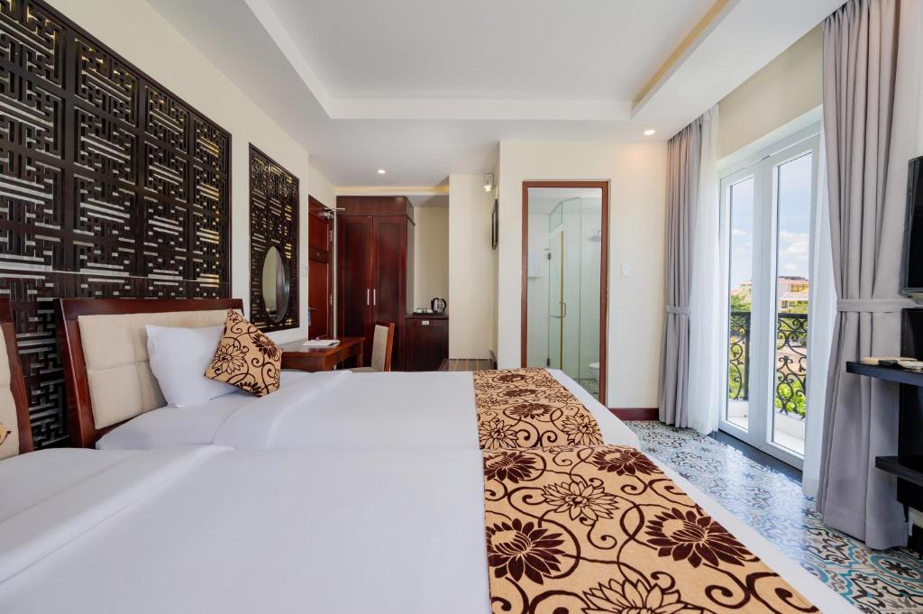 Postel nebo postele na pokoji v ubytování Hoi An Canal House Riverside By Haviland