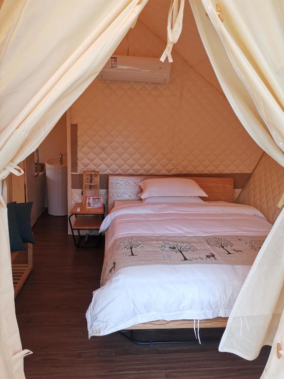 Postel nebo postele na pokoji v ubytování Zhangjiajie Cliff Flower RV Tent Hotel