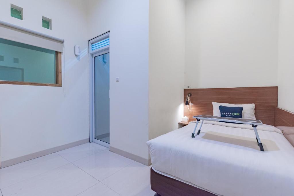 Postel nebo postele na pokoji v ubytování Urbanview Darmo Residence Bandung