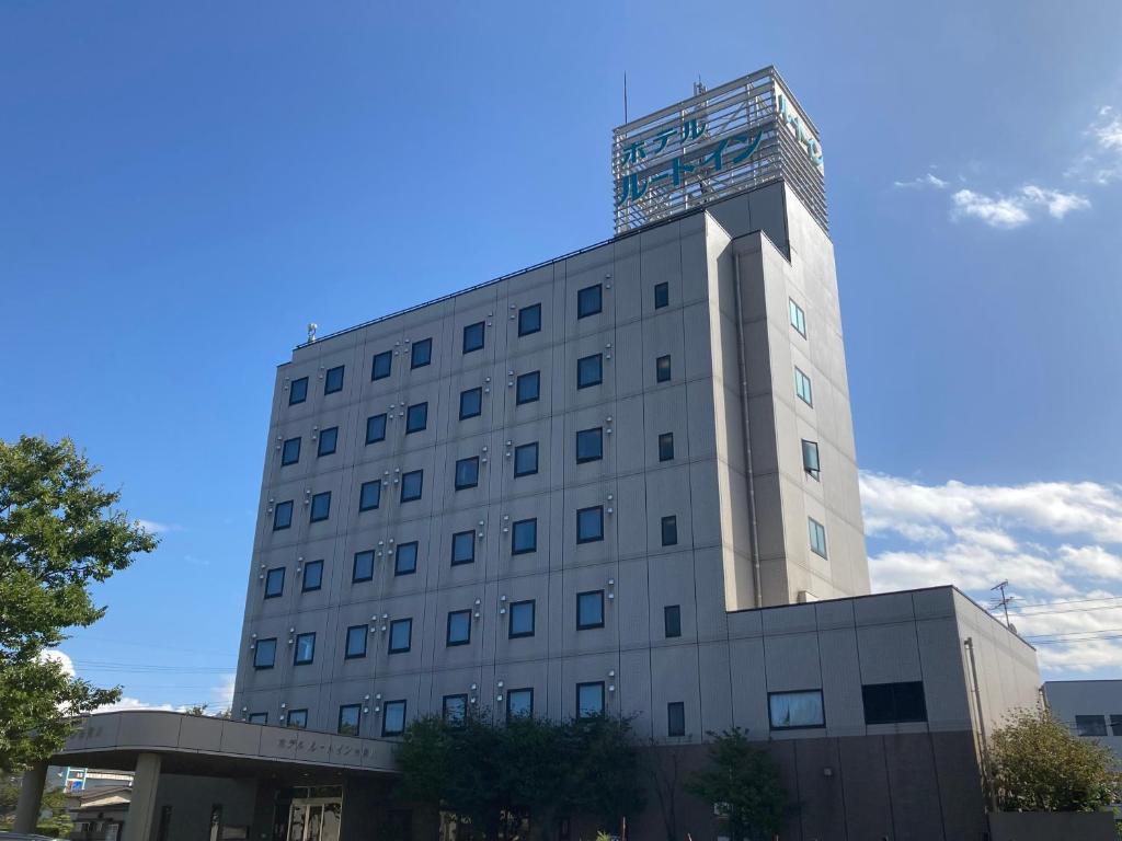 a building with a tower on top of it at Hotel Route-Inn Itoigawa in Itoigawa