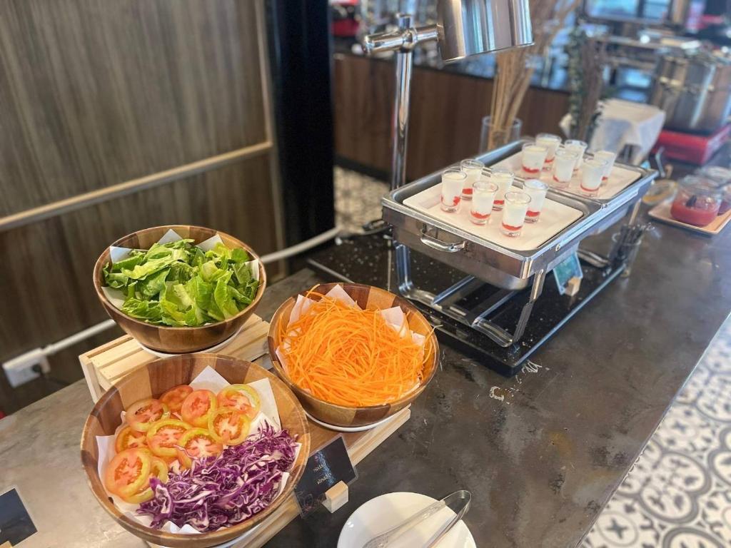 Fresh salad bowls beside a compact toaster and chilled breakfast dishes.