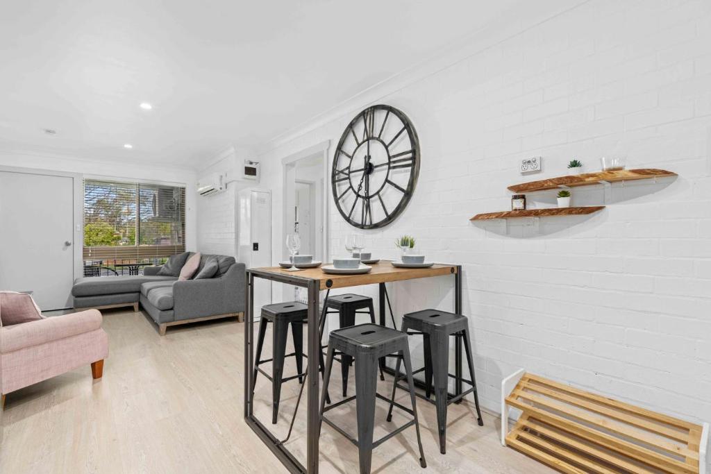 a living room with a table and stools at 2 Cute by Experience Jervis Bay in Huskisson