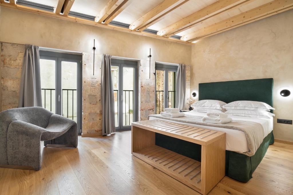 een slaapkamer met een groot bed en een stoel bij Poem Suites in Chania