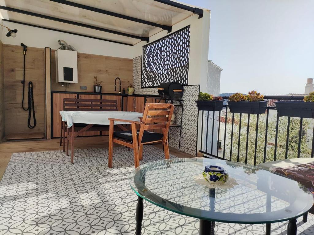 balkon ze szklanym stołem i stolikiem w obiekcie Casa Salomé Frigiliana w mieście Frigiliana