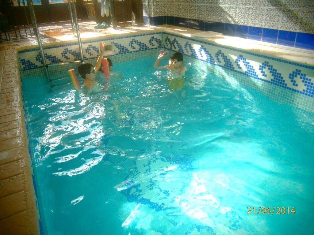 two children swimming in a swimming pool at El Horno de Leopoldo in Hueva