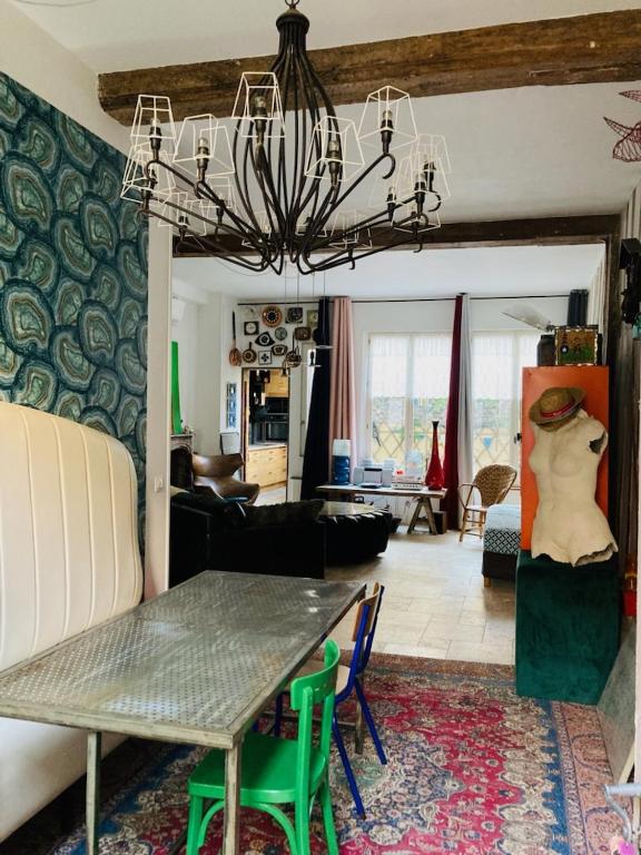 un salon avec une table et un lustre dans l'établissement Atelier des Glycines, Troyes Bouchon de Champagne, Sublime site patrimonial, à Troyes