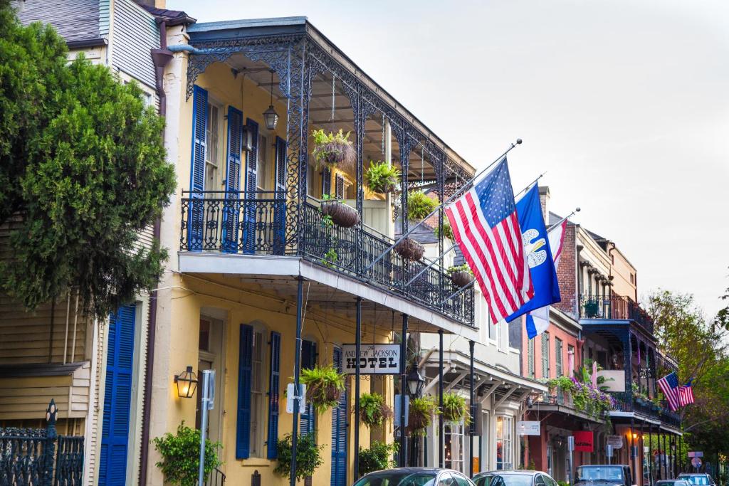 un edificio con banderas al lado de una calle en Andrew Jackson Hotel French Quarter en Nueva Orleans