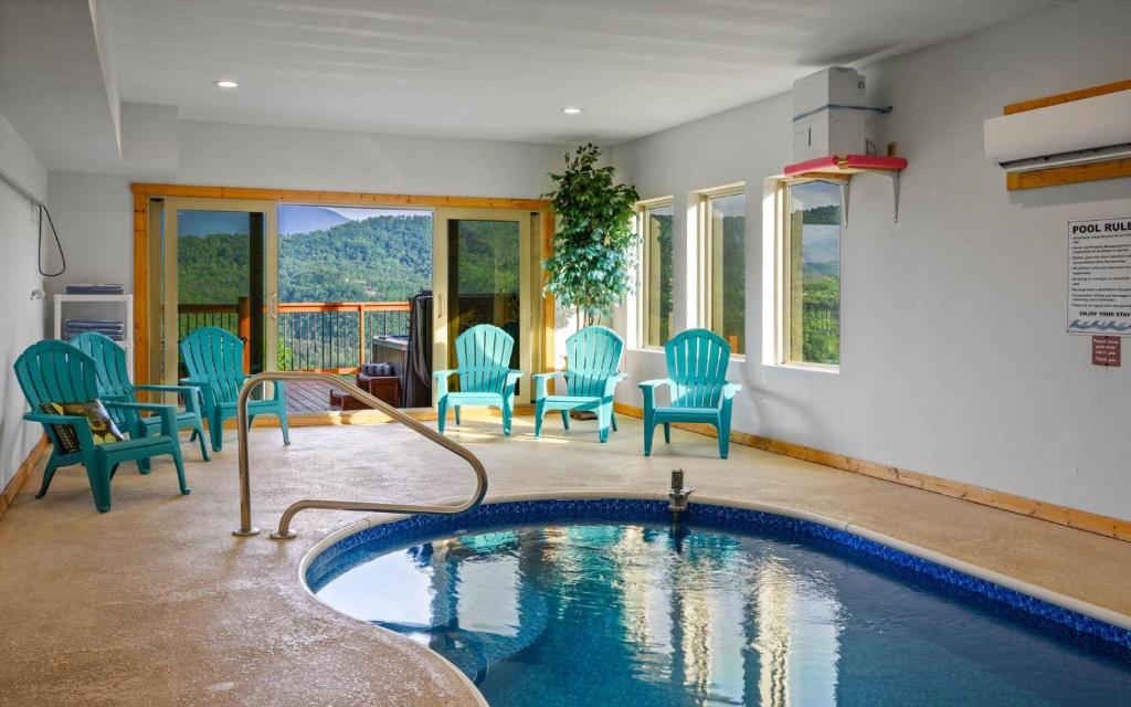 a swimming pool with blue chairs and a table at Grand Mountain View in Pigeon Forge