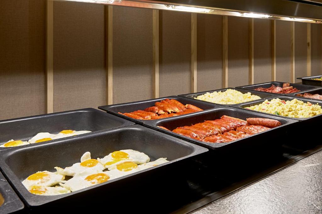 a buffet line with different types of food in trays at tent Bahia de Palma in El Arenal