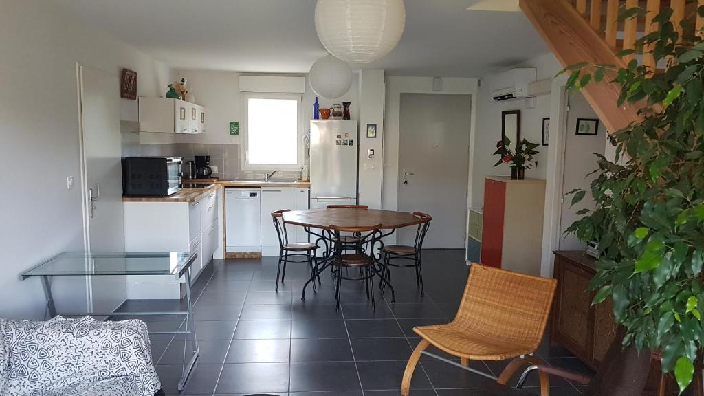 une cuisine et une salle à manger avec une table et des chaises dans l'établissement maison proche du lac, à Aureilhan