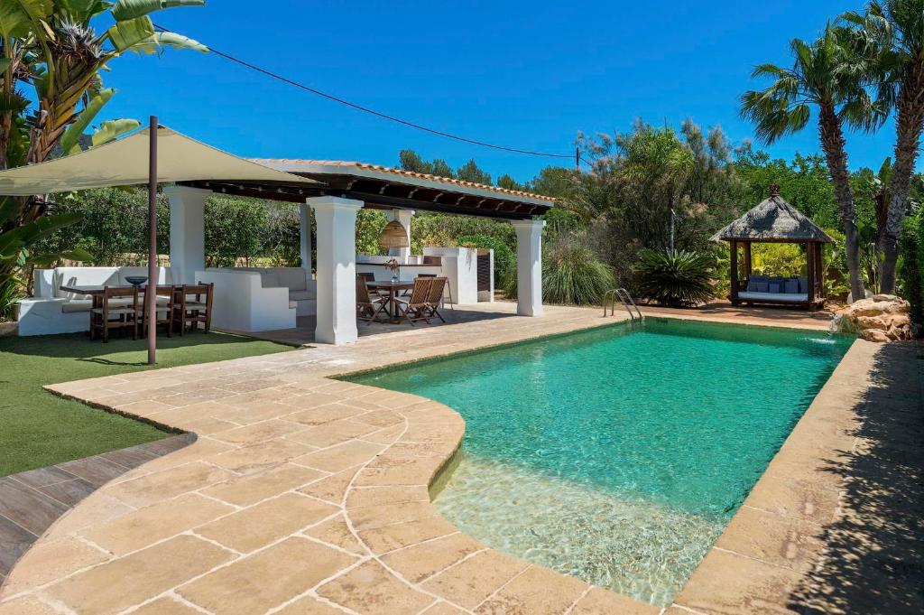 a swimming pool in a yard with a gazebo at Can Botanic in Sant Josep de sa Talaia