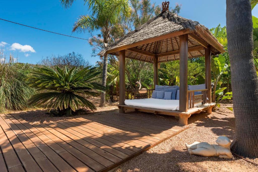 a gazebo with a bed and a tree at Can Botanic in Sant Josep de sa Talaia