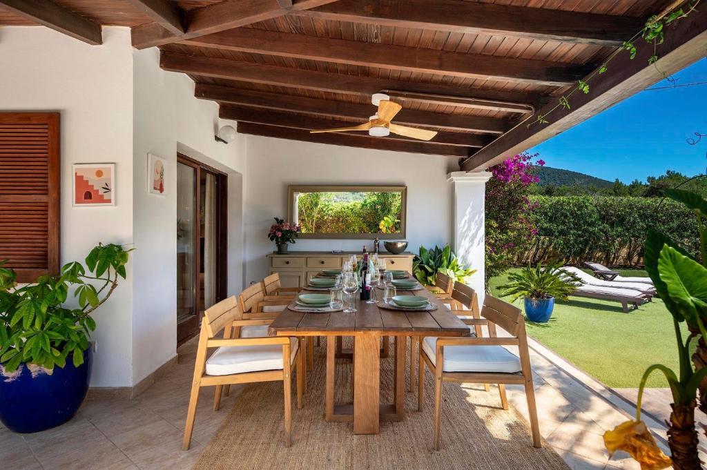 a dining room with a wooden table and chairs at Can Botanic in Sant Josep de sa Talaia