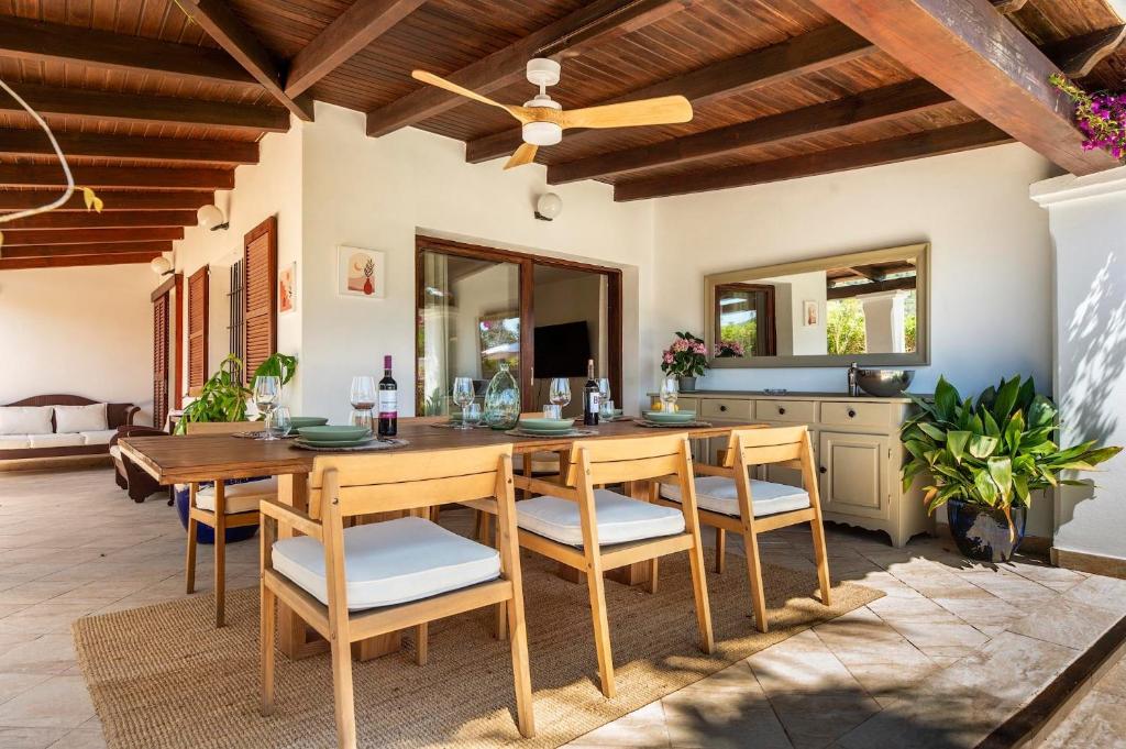 a dining room with a wooden table and chairs at Can Botanic in Sant Josep de sa Talaia